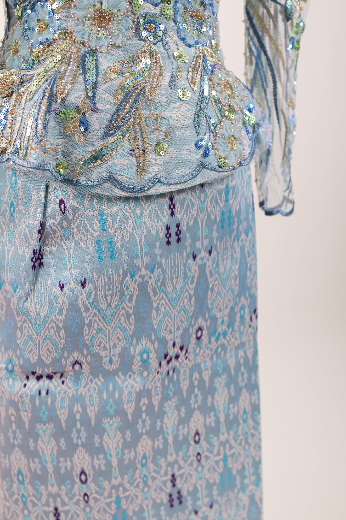Decorative fabric with intricate patterns and embellishments on a plain background