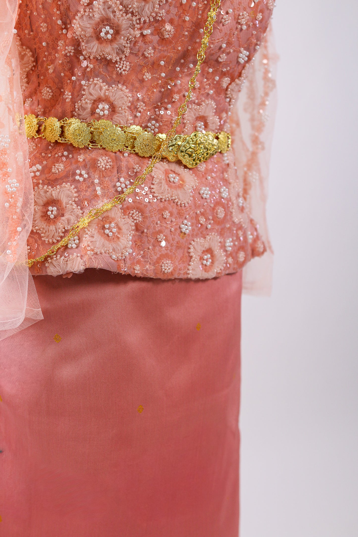 Pink traditional outfit with gold embroidery on a white background
