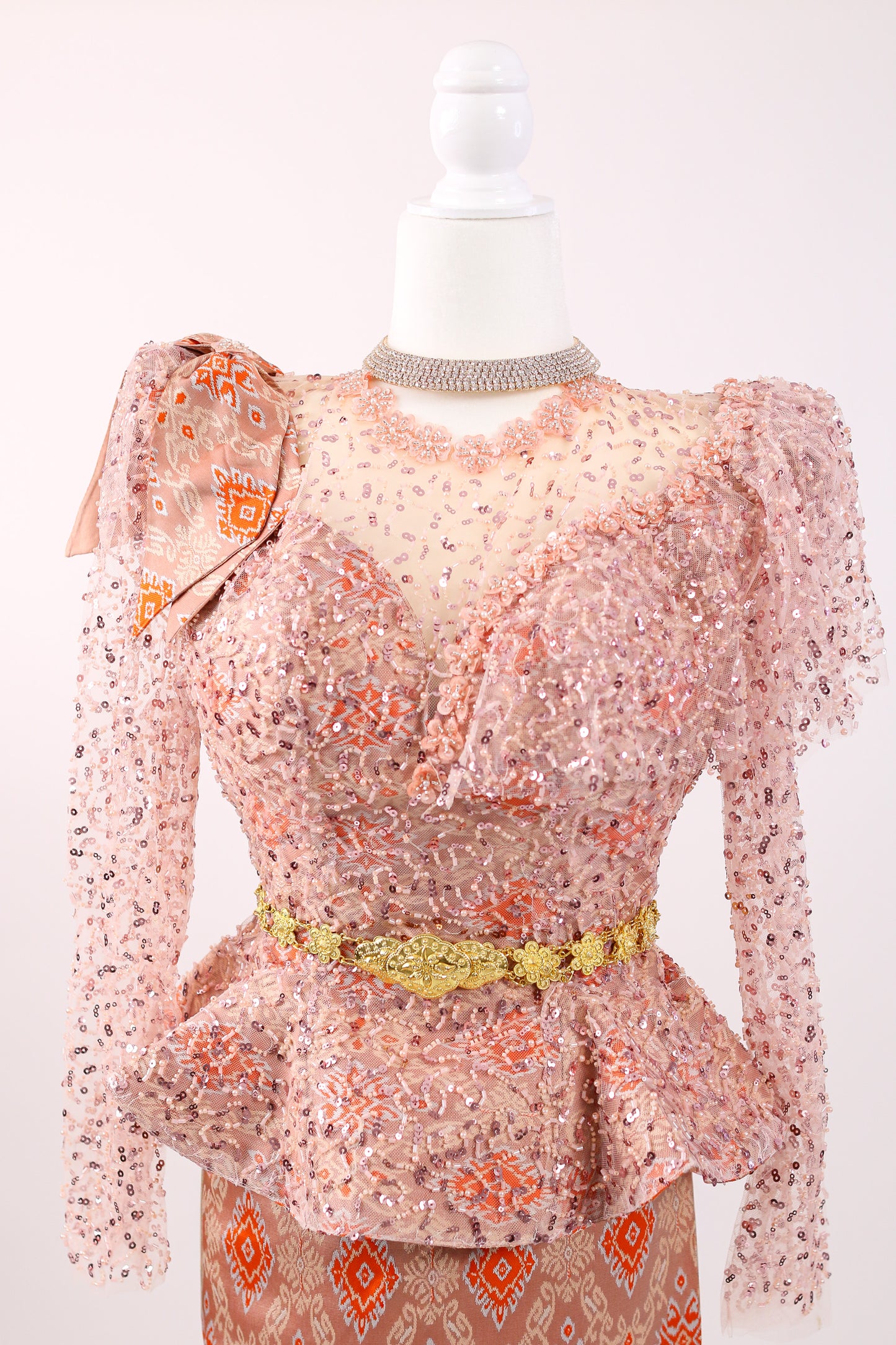 Sheer floral dress with long sleeves on a mannequin against a white background