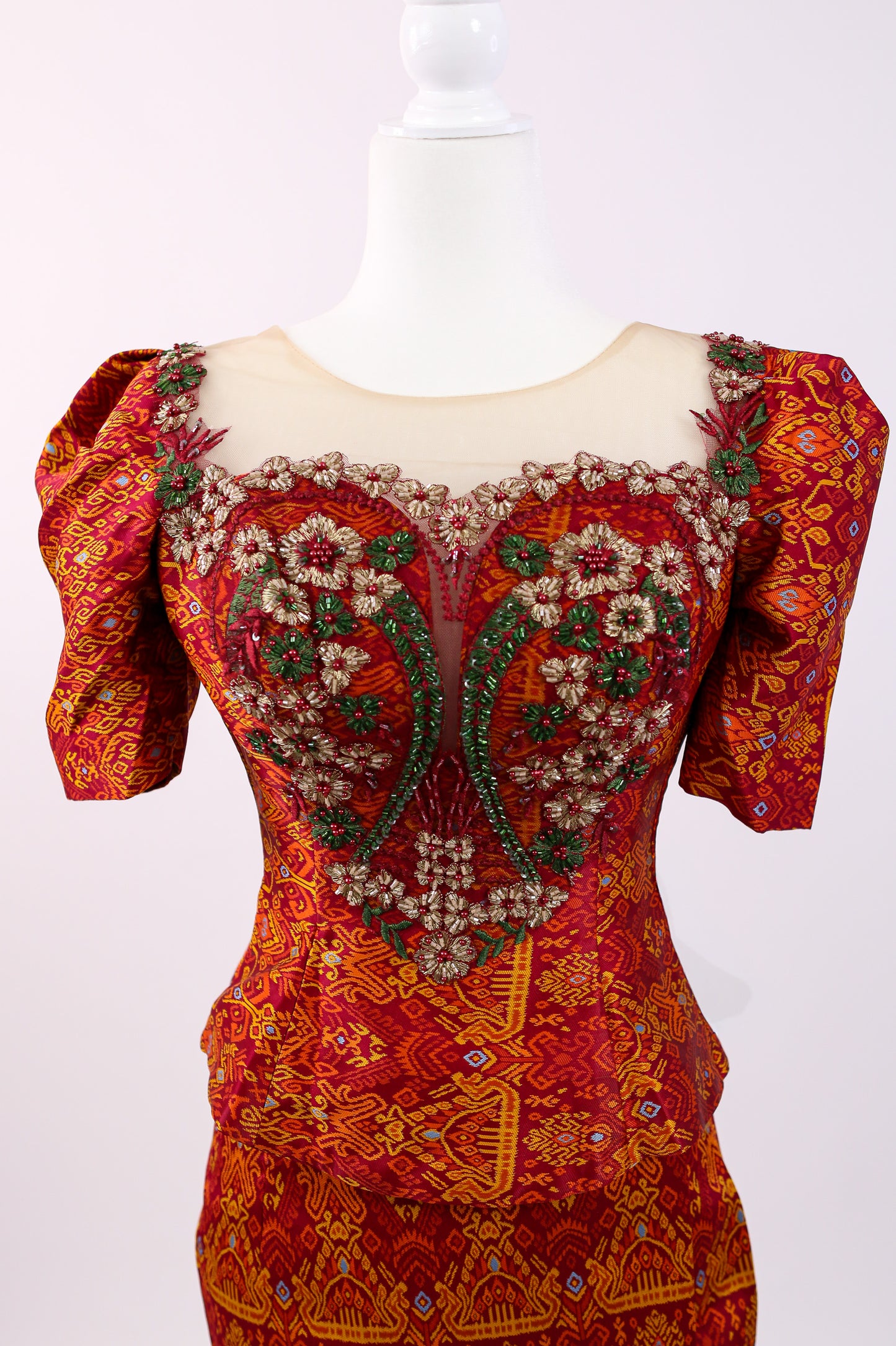 Decorative dress with intricate patterns on a mannequin against a white background