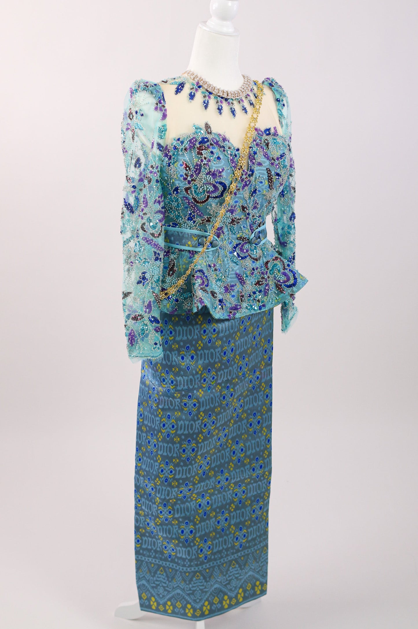 Mannequin wearing a blue and green patterned outfit on a white background