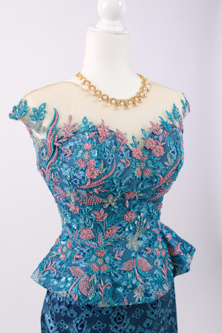Blue embroidered top on a mannequin with a white background