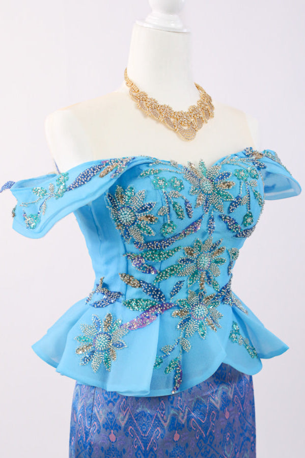 Mannequin wearing a blue embroidered outfit with a white background