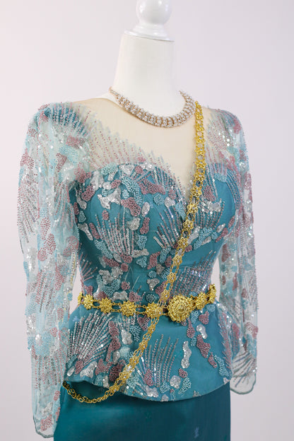 Mannequin wearing a teal dress with floral patterns and gold accents on a white background