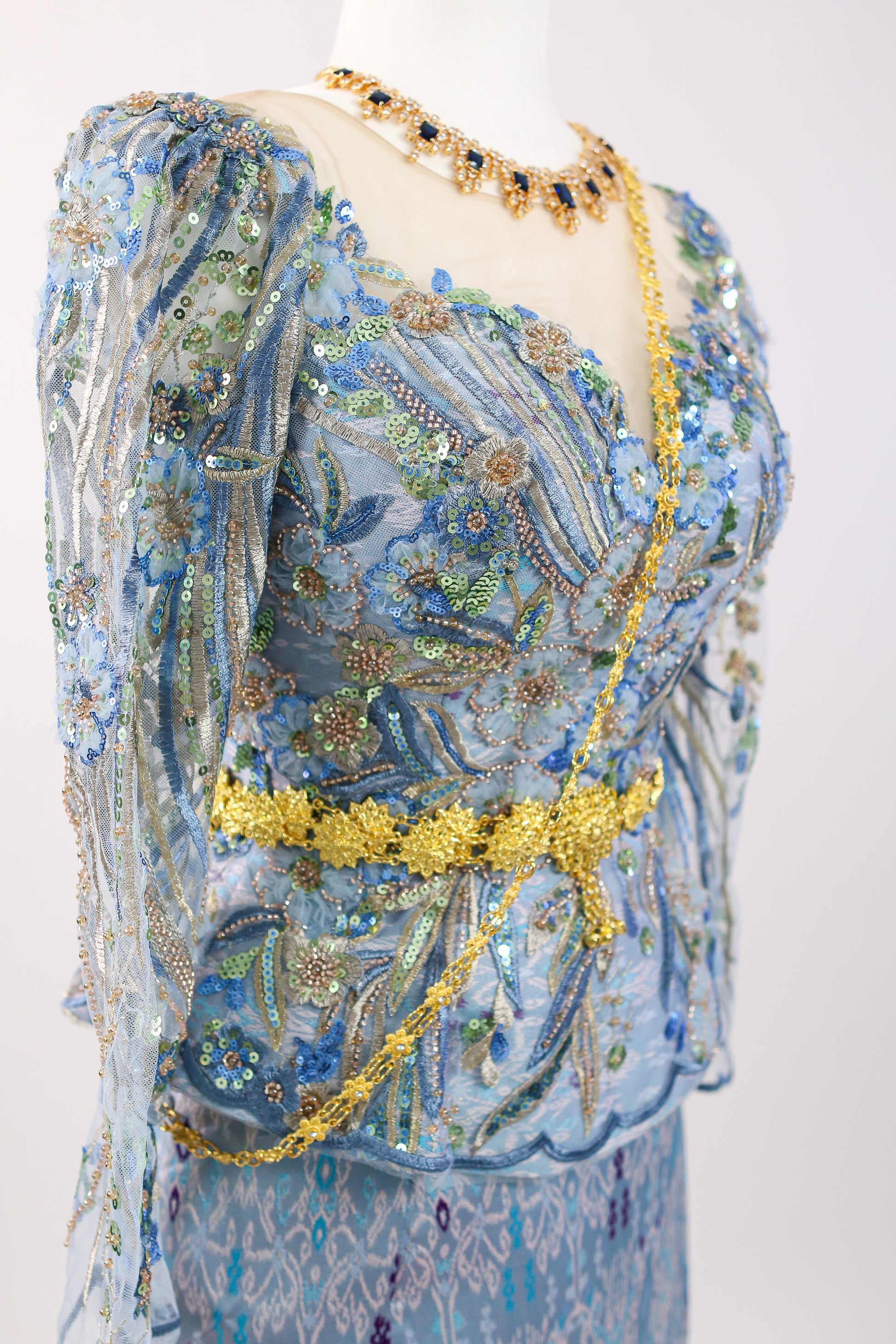 Decorative dress with floral patterns and gold accents on a white background
