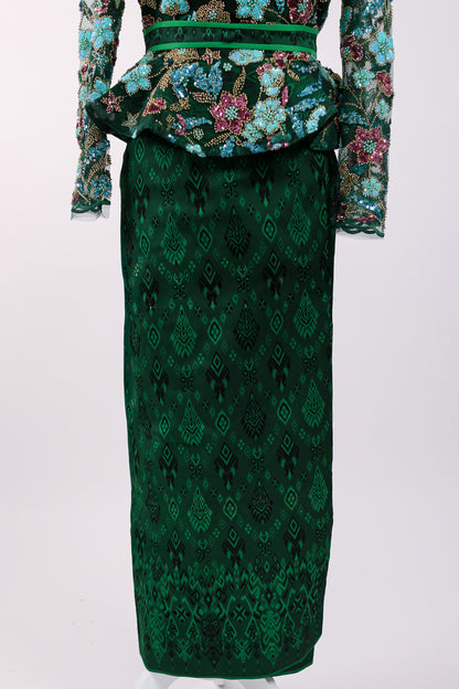 Green patterned dress with floral embellishments on a white background