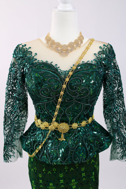 Green embroidered dress with gold accents on a mannequin against a white background