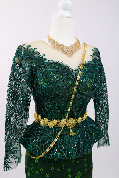 Green lace dress with gold accents on a mannequin against a white background