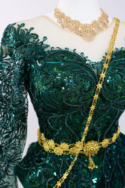 Green embroidered dress with gold accents on a mannequin against a white background