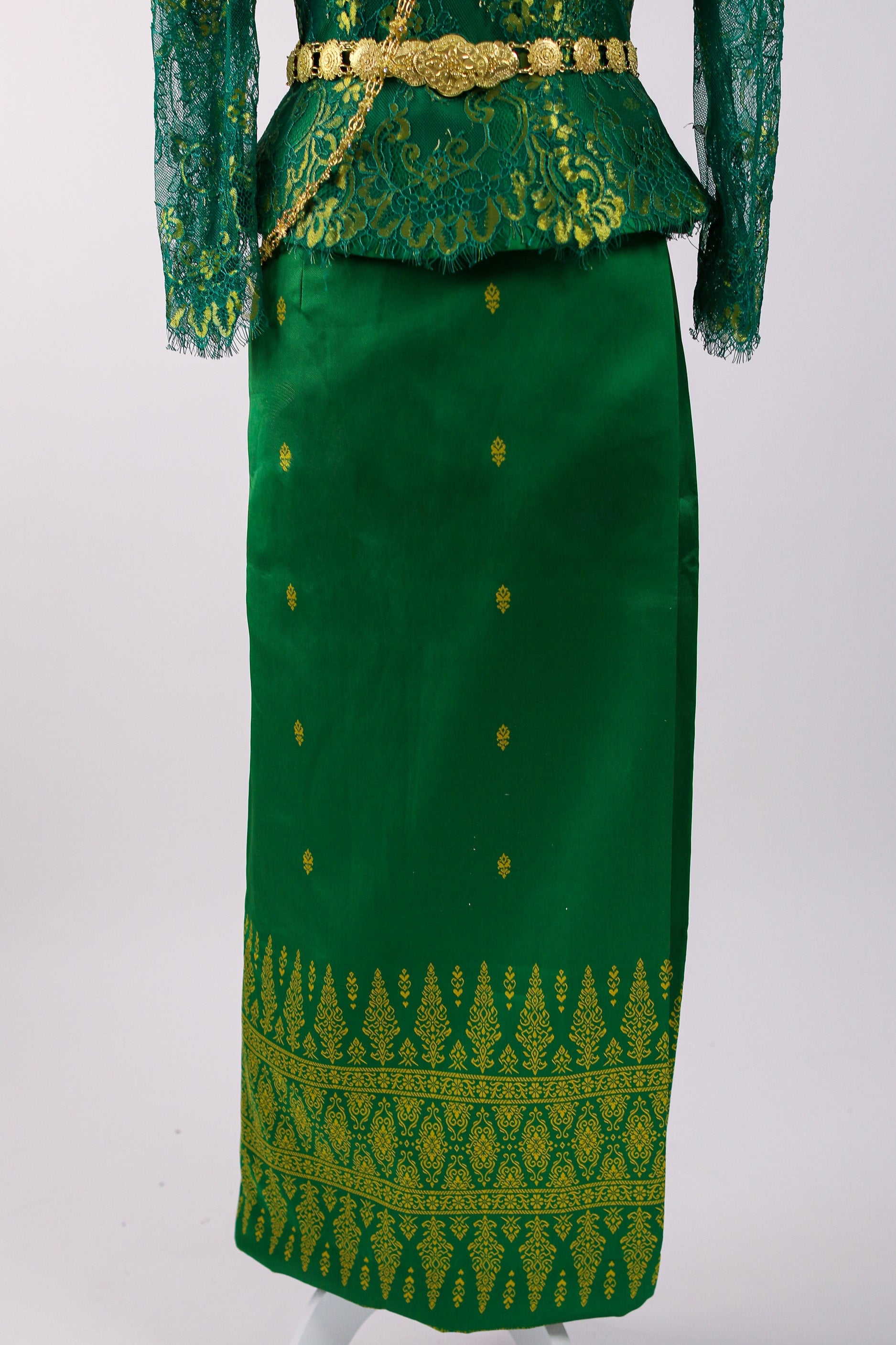 Green traditional outfit with gold patterns and a belt on a white background