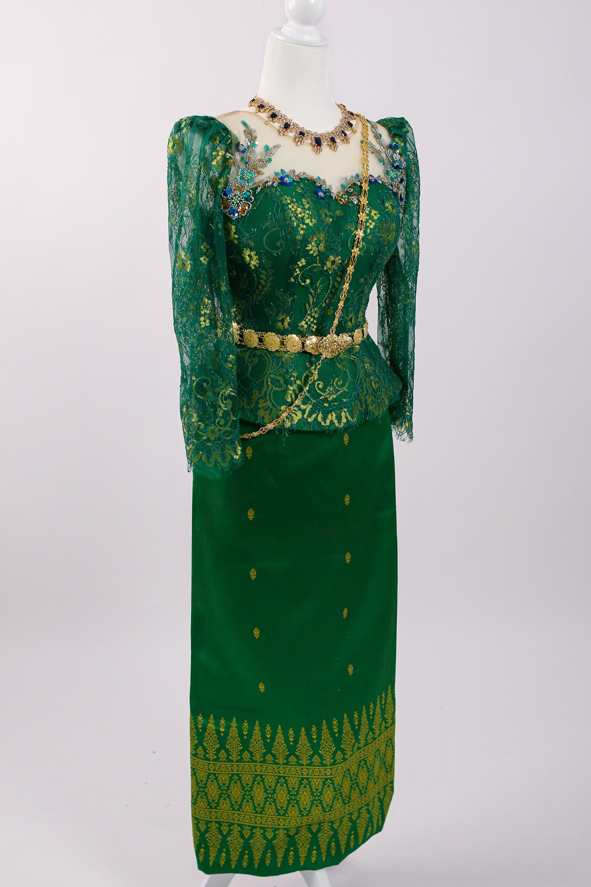 Green traditional outfit with intricate patterns on a white background