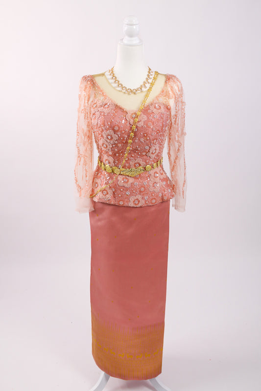 Traditional outfit with a pink top and skirt on a mannequin against a white background