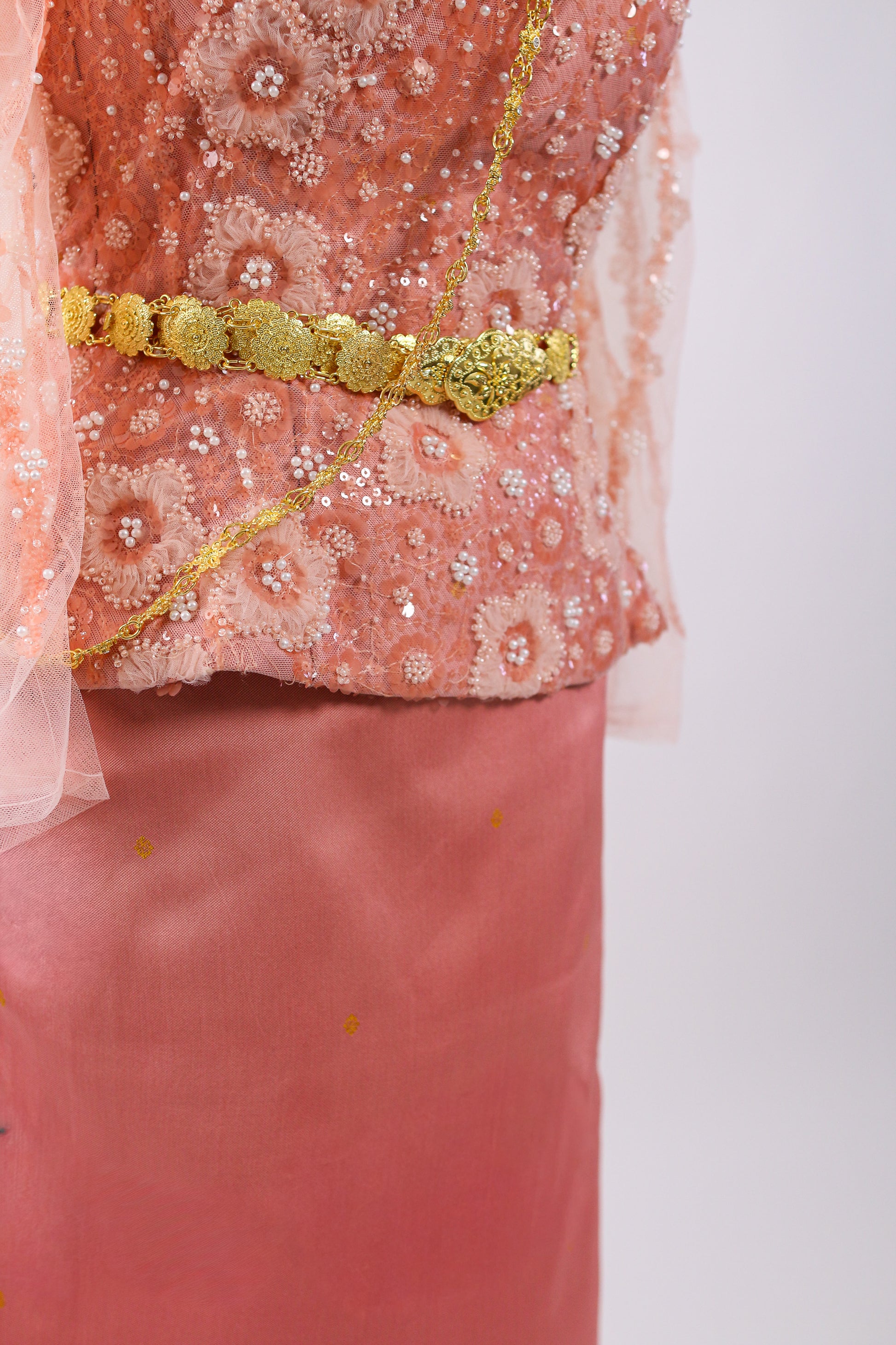 Pink traditional outfit with gold embroidery on a white background