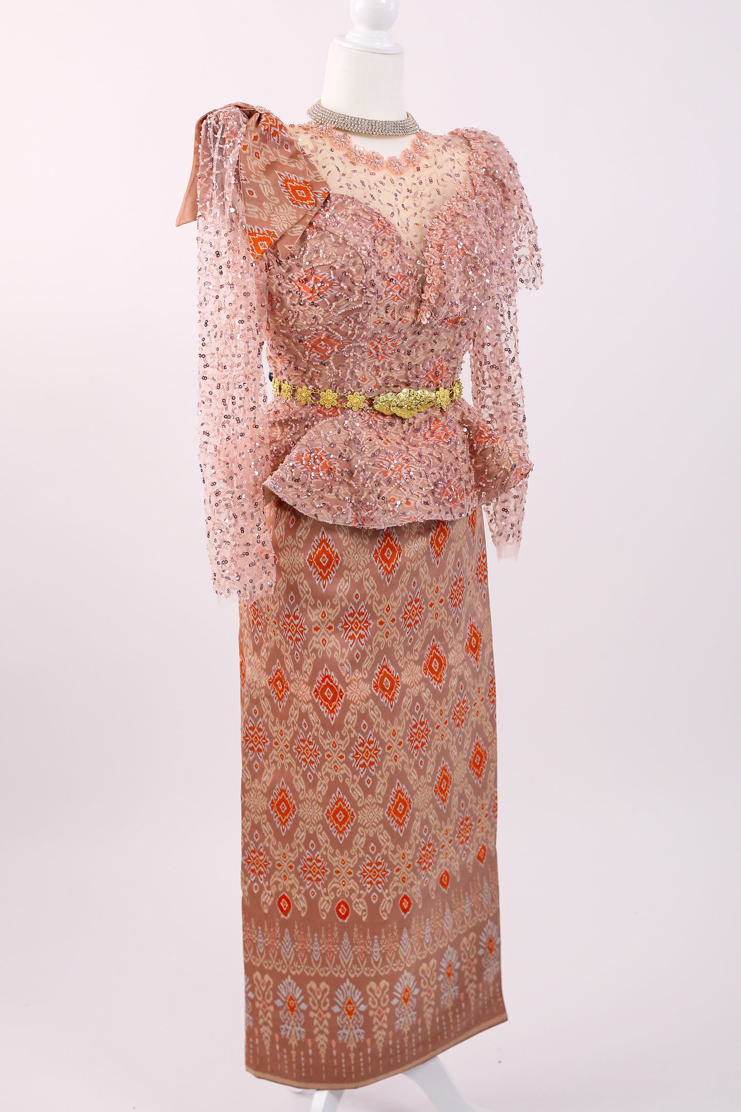 Two-piece outfit with a patterned top and skirt on a mannequin against a white background