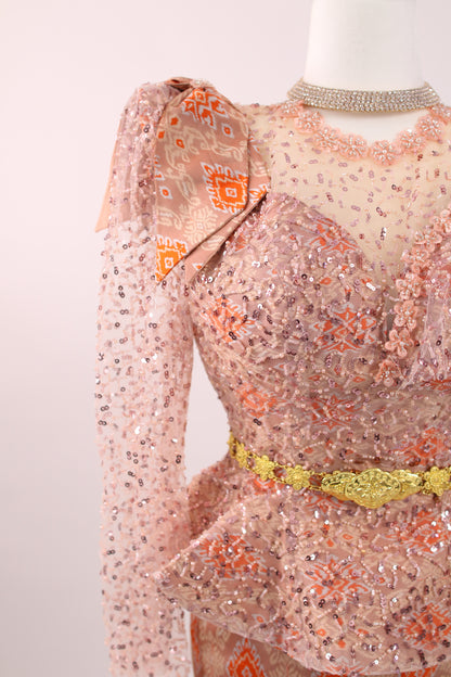 Mannequin wearing a floral dress with a patterned top and sheer sleeves on a plain background