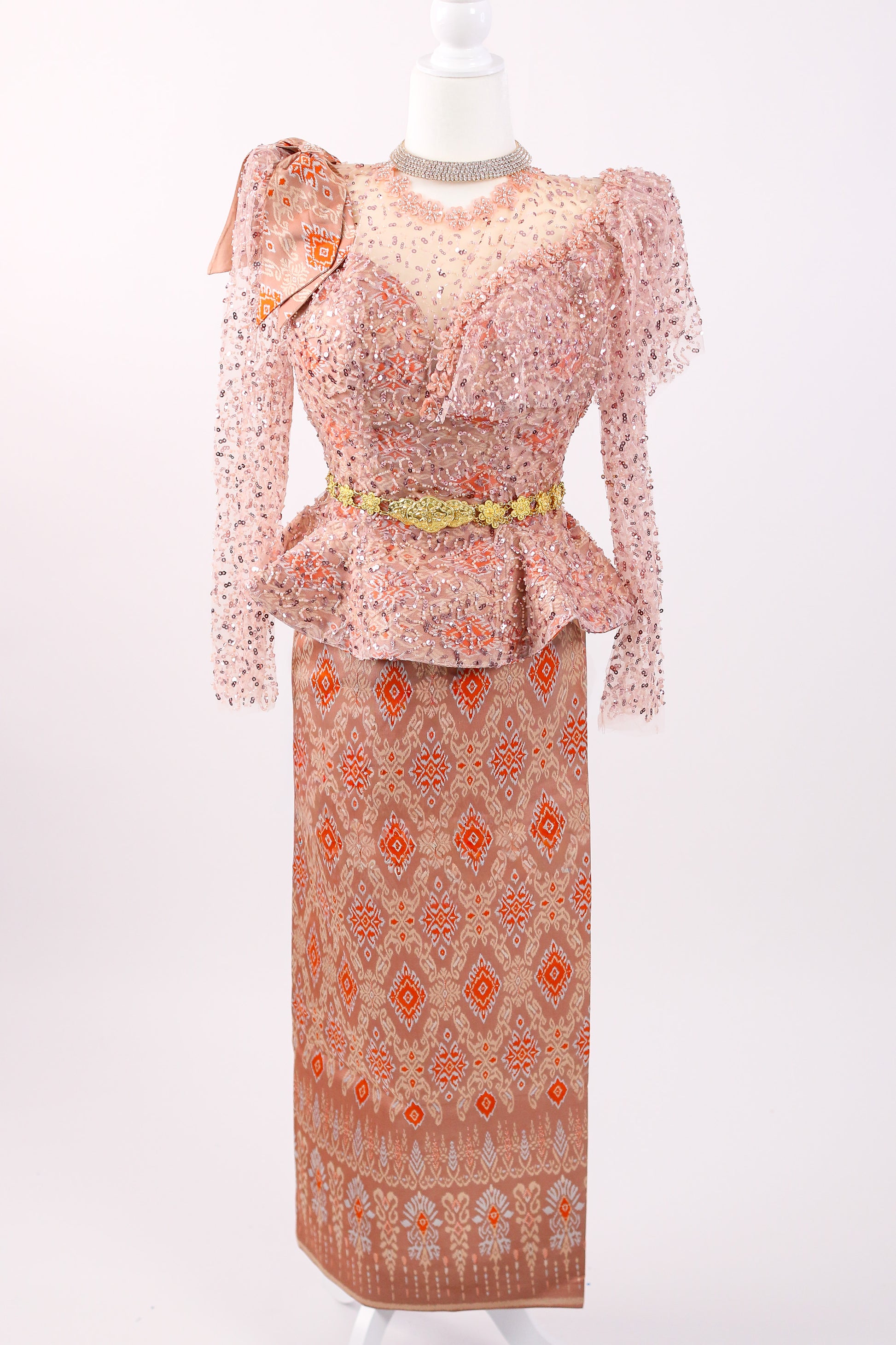 Traditional outfit with a patterned top and long skirt on a mannequin against a white background