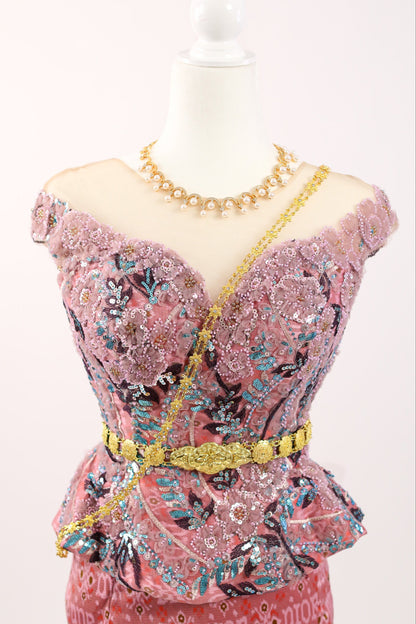 Pink dress with floral patterns and gold accents on a mannequin against a white background
