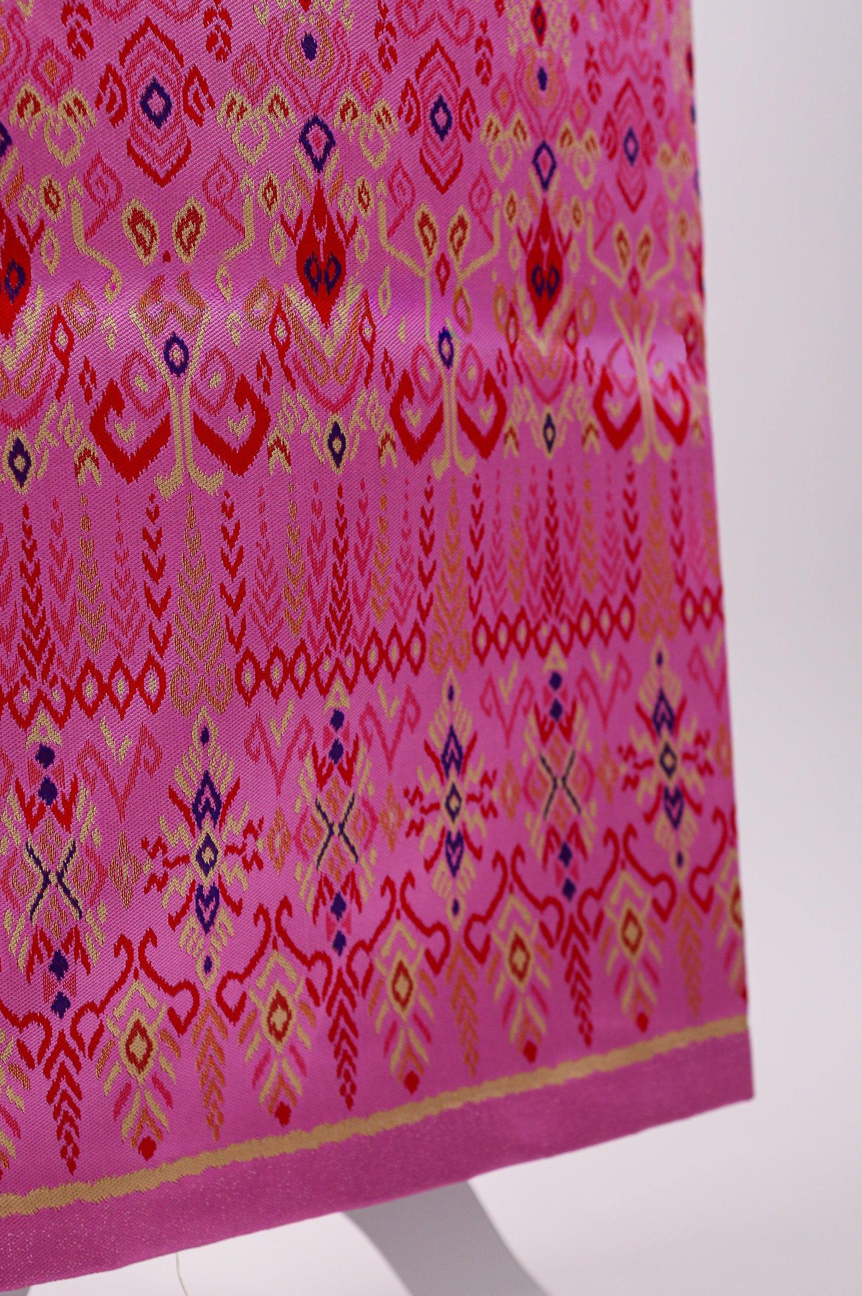 Pink fabric with a geometric pattern on a white stand