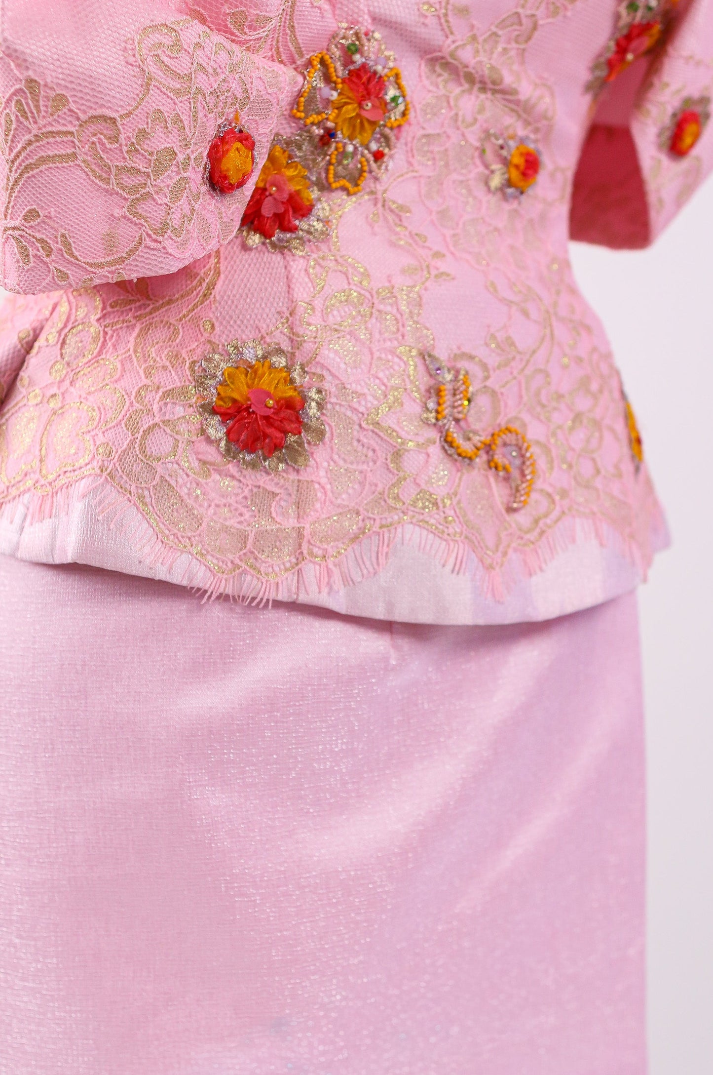Pink traditional outfit with floral embroidery on a white background