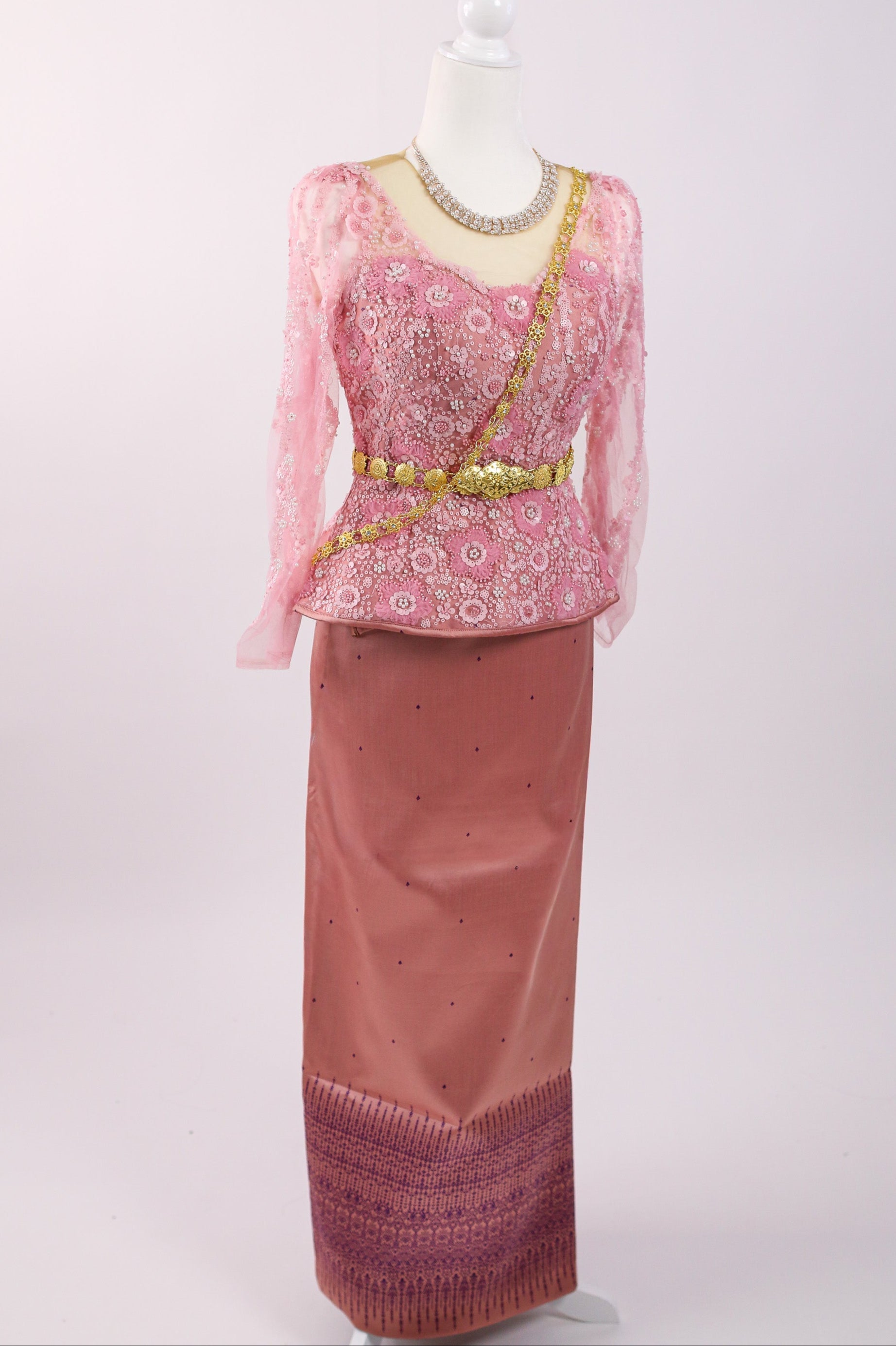 Traditional pink and gold outfit on a mannequin against a white background