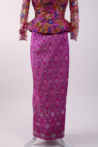 Traditional outfit with floral top and pink patterned skirt on a white background