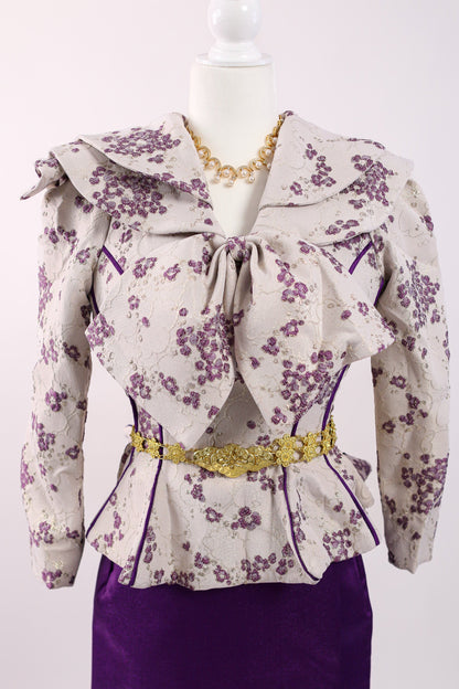 Floral blouse with a bow and purple skirt on a mannequin against a white background