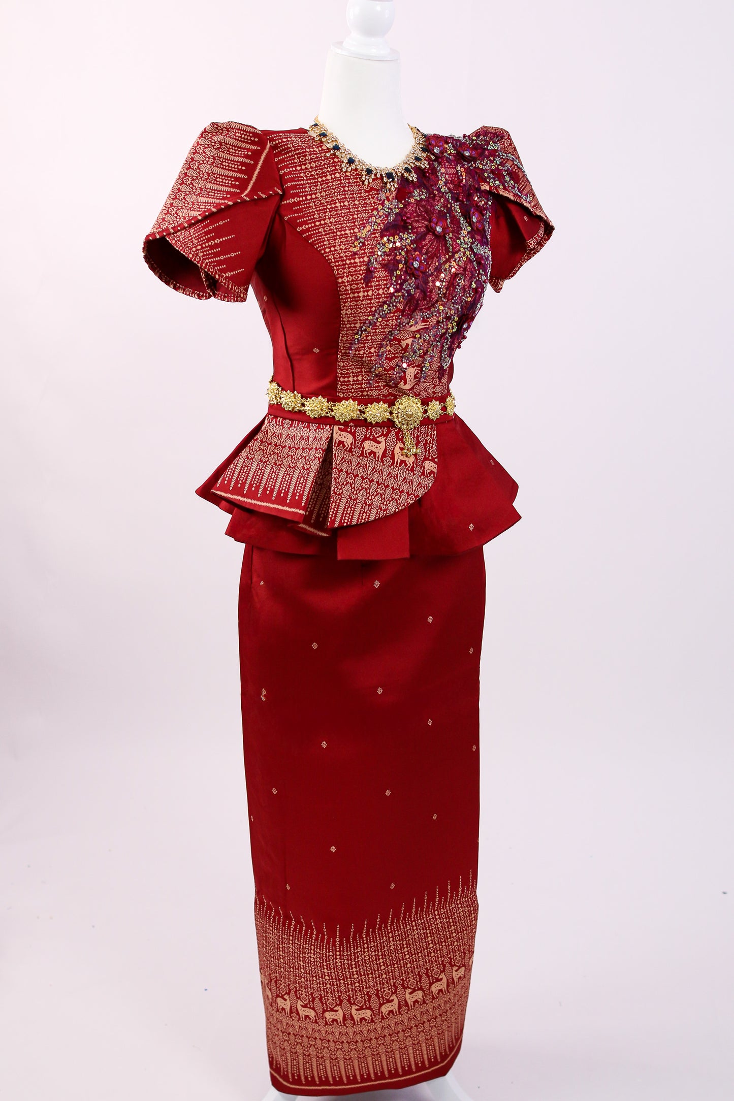 Red dress with intricate patterns and embellishments on a white background