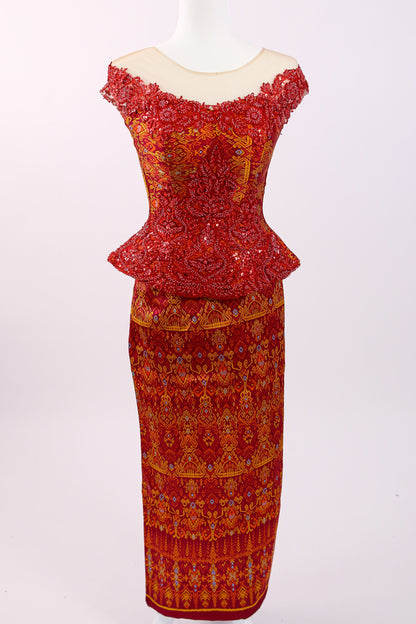 Red and orange patterned dress on a white mannequin against a white background