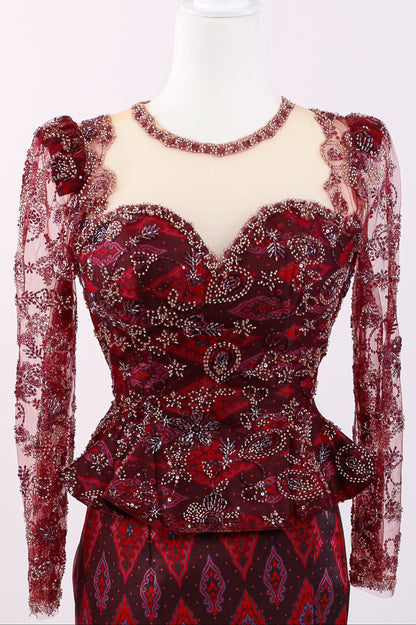 Red lace dress with intricate patterns on a mannequin against a white background