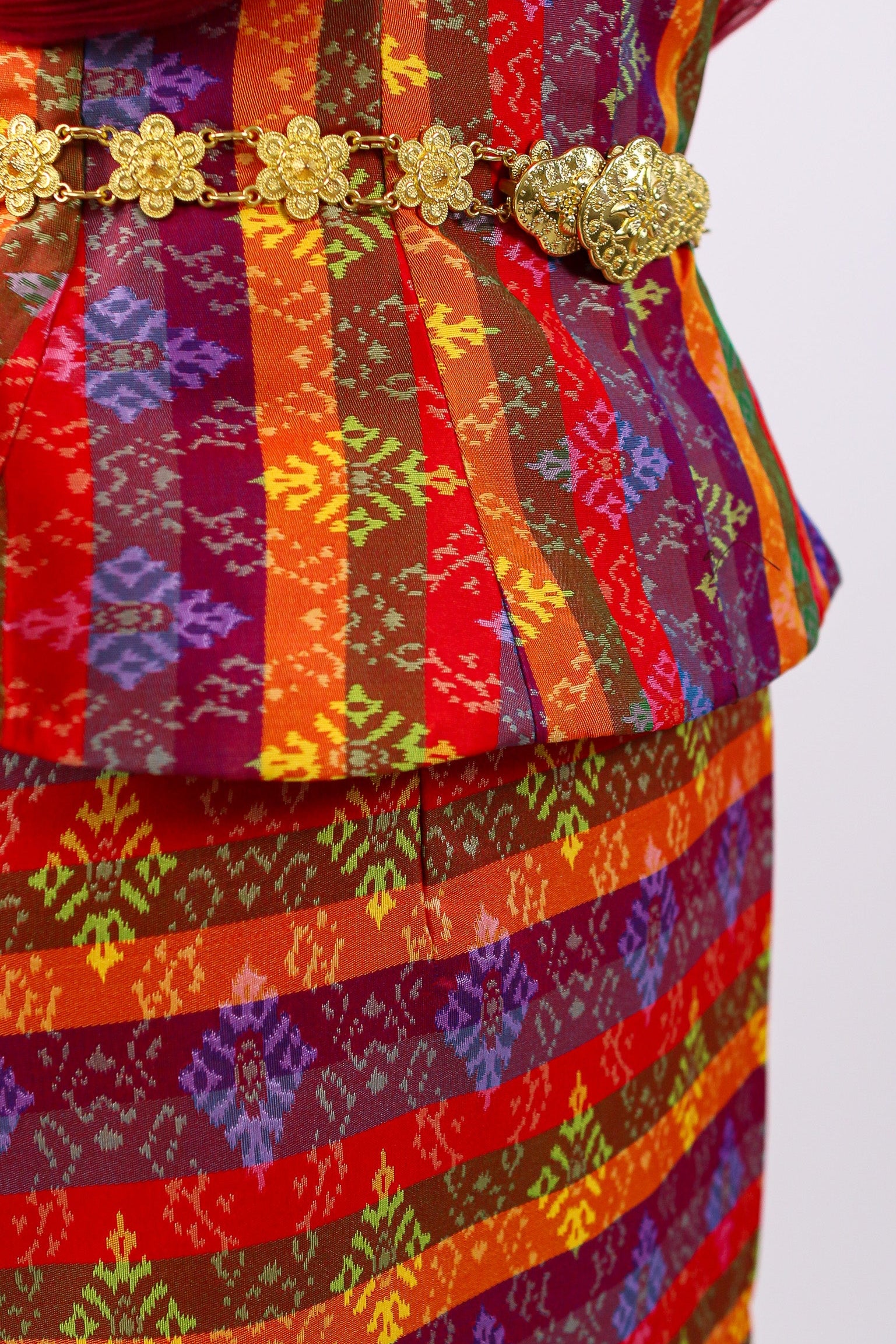Colorful traditional outfit with a patterned skirt and red top on a white background