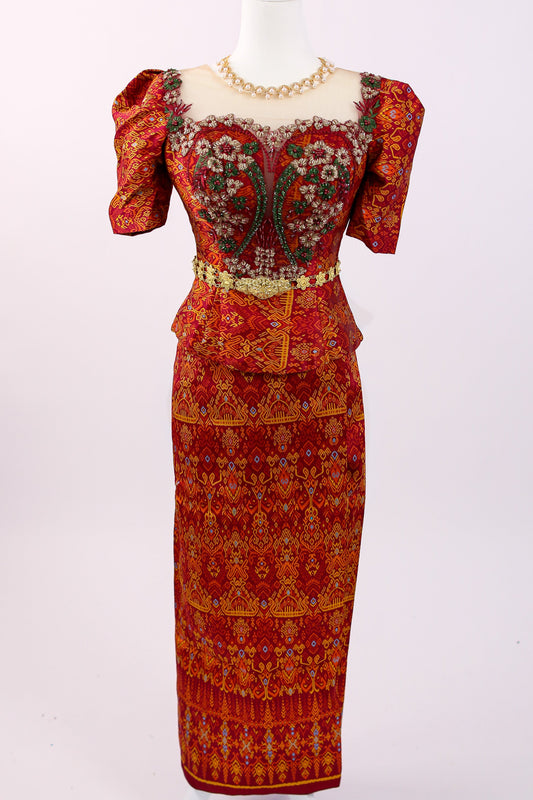 Red patterned dress on a mannequin against a white background
