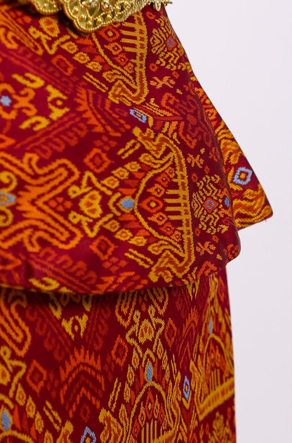 Traditional patterned outfit with a gold belt on a white background