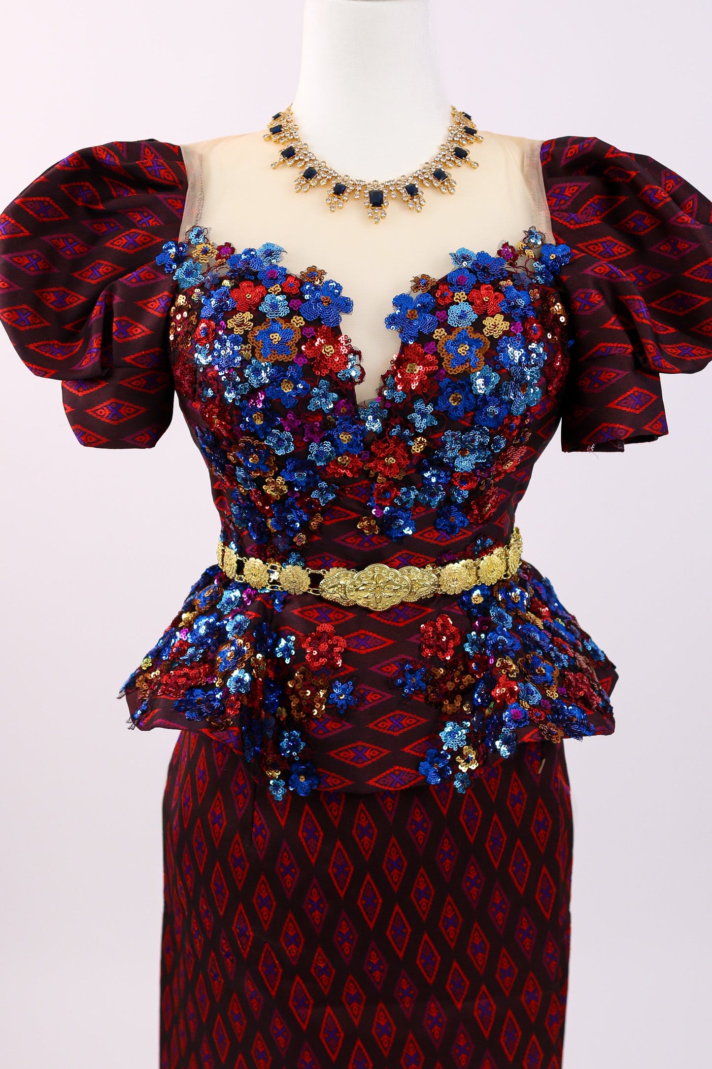 Colorful dress with floral patterns on a mannequin against a white background